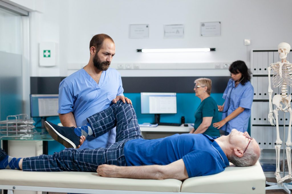 Orthopedic nurse helping patient with knee injury